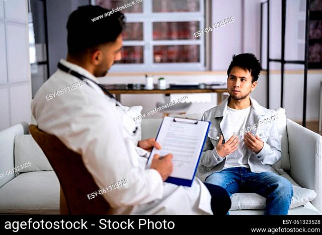 Doctor With Young Asian Patient Living At Home