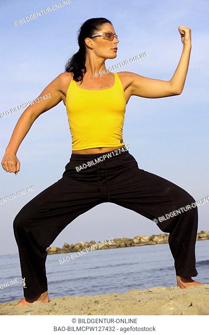 Woman does gymnastics on the beach