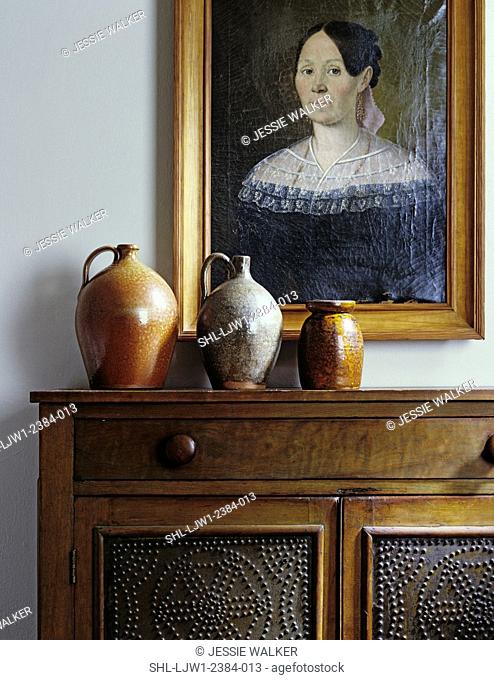 LIVING ROOM DETAILS: Still life, sideboard with three salt glaze jugs, punched tin panels on walnut cabinet, portrait oil painting of woman