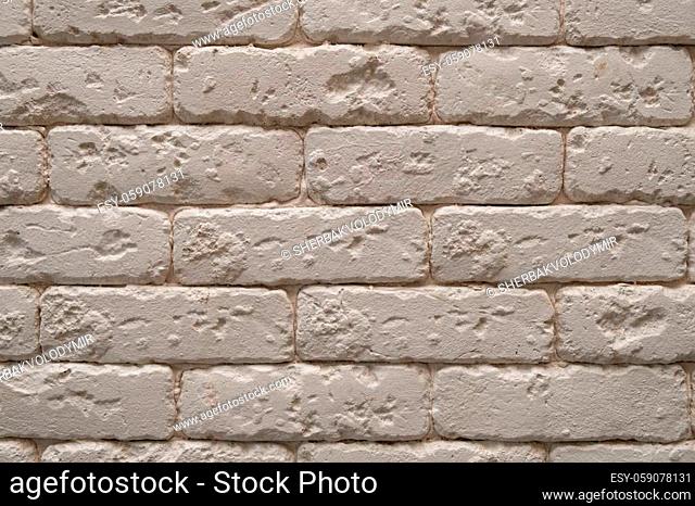 A white or beige brick wall background. Space for text