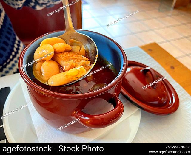 Serving beans stew from a pot. Spain