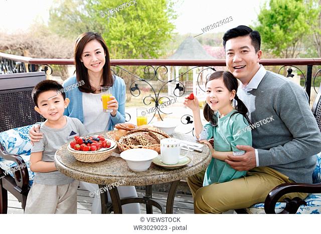 Happy families eat breakfast on the terrace