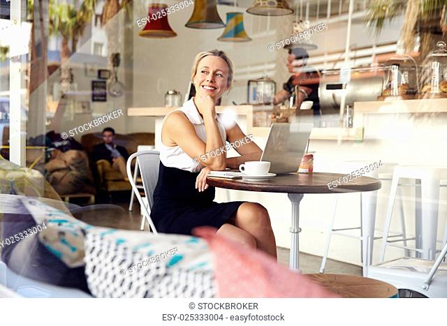 Business woman sitting in small coffee shop