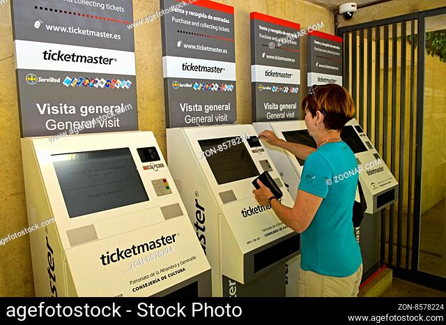 Besucher kauft Eintrittskarten an den modernen Ticketautomaten am Eingang zur Alhambra, Granada, Andalusien, Spanien / Visitor buying tickets at the modern...