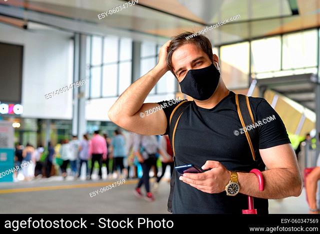 Portrait of Persian tourist man with mask for protection from corona virus outbreak at the mall in the city outdoors