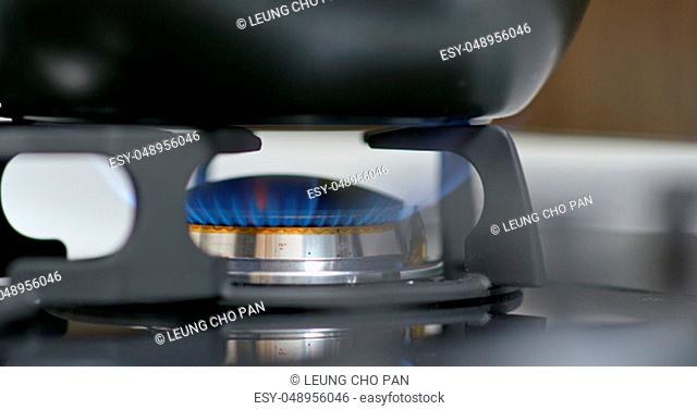 Stove top burner igniting into a blue for cooking