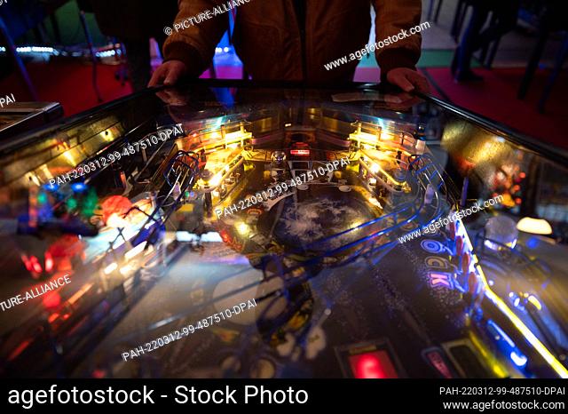 PRODUCTION - 05 March 2022, Hessen, Seligenstadt: A man plays a pinball machine at the Pinball and Arcade Museum. The museum