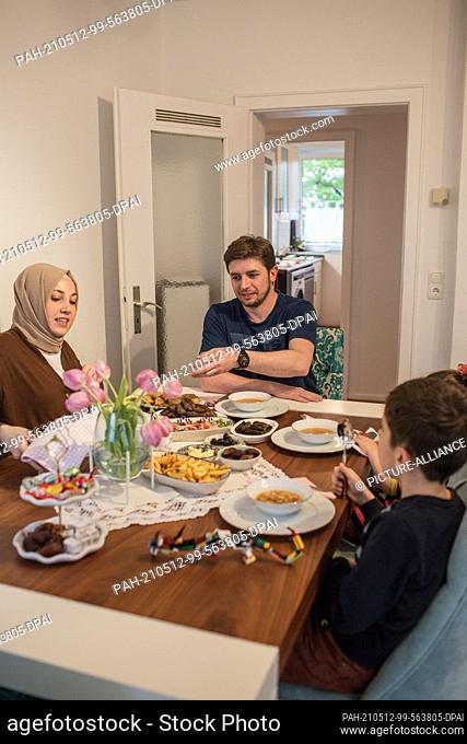 PRODUCTION - 10 May 2021, North Rhine-Westphalia, Minden: Hatice Bahadir (l-r), Abdurrahman Bahadir and their children have an iftar (breaking of the fast) meal...