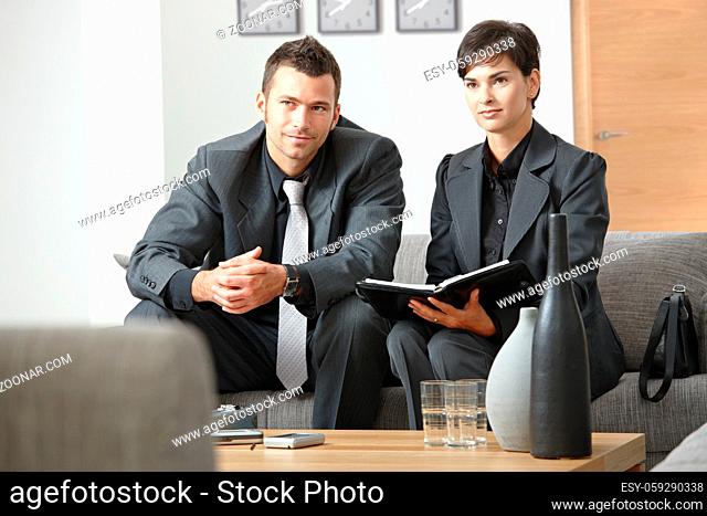 Young business people having meeting at office sitting on sofa working in team