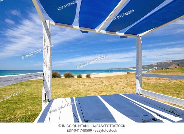 beautiful landscape of Bolonia Beach from a wooden Balinese bed with blue surf boards, in Tarifa (Cadiz, Andalusia, Spain)