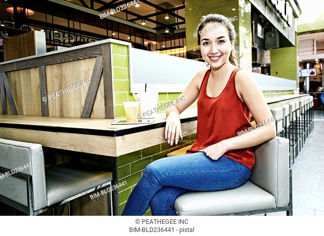 Smiling Mixed Race woman posing in food court