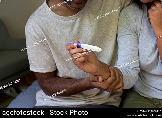 Close up of a woman's hand holding a pregnancy test kit