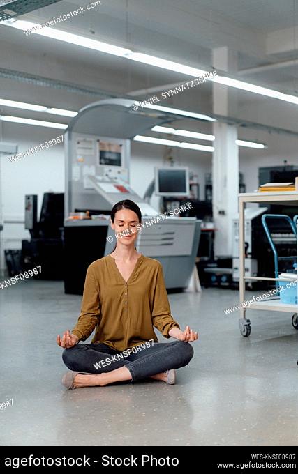 Businesswoman practicing yoga in workshop