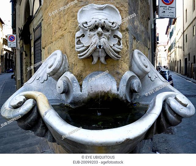 Oltrarno District Drinking water fountain with gargoyle on corner building in Piazza deFrescobaldi designed by Buontalenti in the 16th Century with narrow...