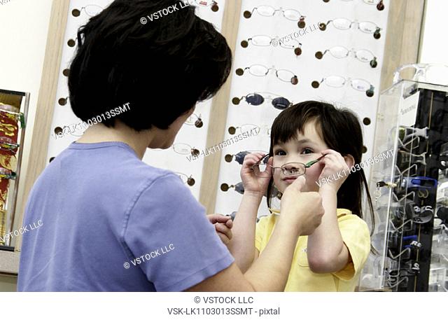 Asian mom and daughter choosing eyeglasses