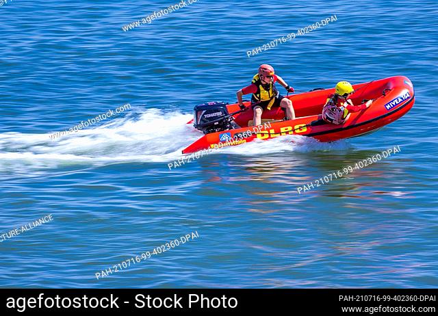 15 July 2021, Mecklenburg-Western Pomerania, Prerow: Lifeguards Jasmin Luciani (l) and Pauline Geipel (r) from the DLRG water rescue team cross the Baltic Sea...