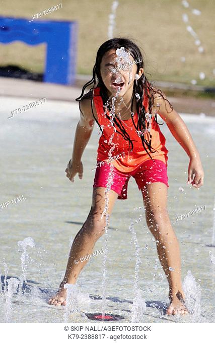 A little girl playing in the water at a water park