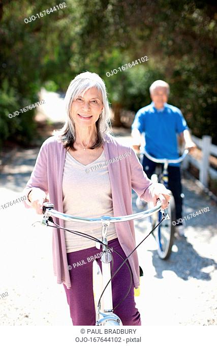 Smiling older couple riding bicycles