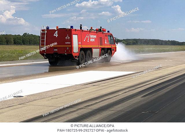 HANDOUT 25 July 2018, Hanover, Germany: A fire engine of the Hannover-Langenhagen Airport fire brigade is watering the northern runway to prevent renewed...