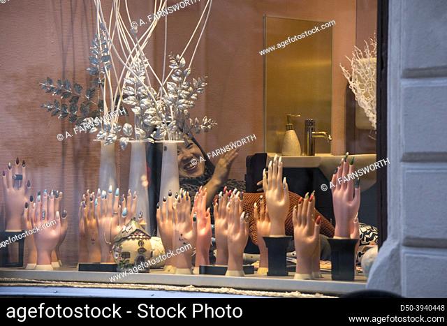Sundsvall, Sweden An oriental woman waving in a hair salon window with hand models