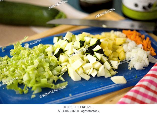 Finely chopped vegetables on blue cutting board