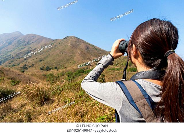 The back view of woman watching though binocular