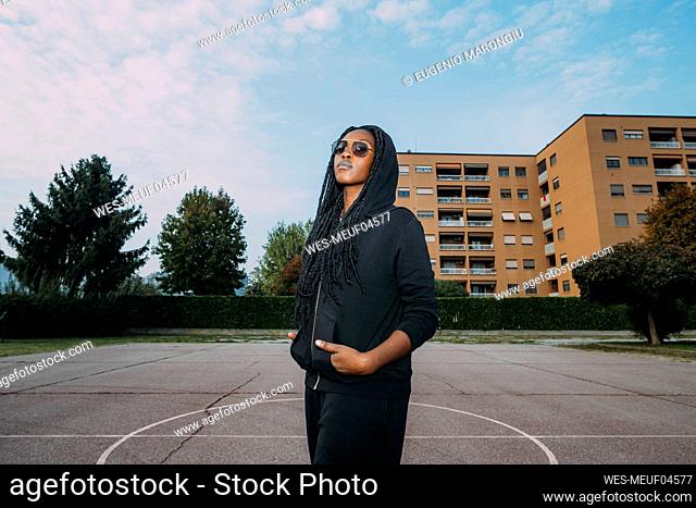 Woman with hands in pockets at sports court