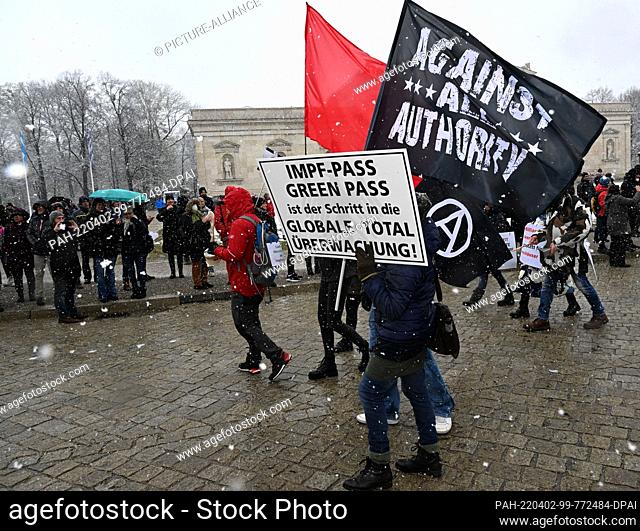 02 April 2022, Bavaria, Munich: Demonstrators walk under the motto ""We run for self-determination in vaccination"" with a poster with the inscription...