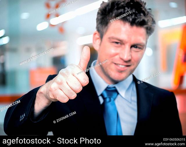 Portrait of Happy handsome business man holding thumbs up