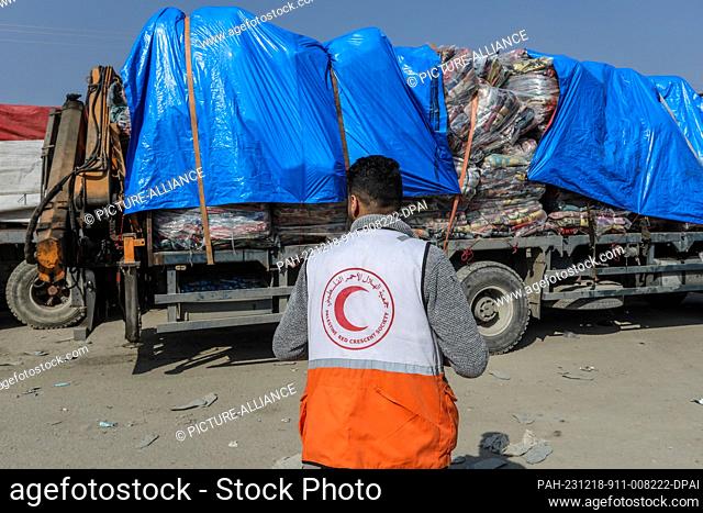 18 December 2023, Palestinian Territories, Rafah: A Palestinain Red Crescent worker looks on as aid trucks enter Gaza through the Kerem Shalom commercial...