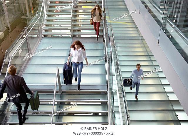 Germany, Cologne, People walking up and down stairs with baggage at Bonn airport