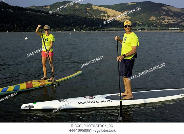 Model release yes. MacRae Wylde and Eva DeWolfe paddle boarding on the Columbia River, Oregon. Hood River. USA. Summer