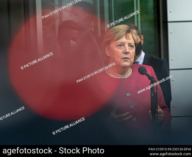 15 September 2021, Bavaria, Garching: German Chancellor Angela Merkel speaks to waiting journalists behind the red recording light of a TV camera after her...