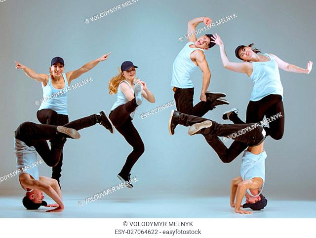 Group of men and women dancing fitness or hip hop choreography in gray studio background