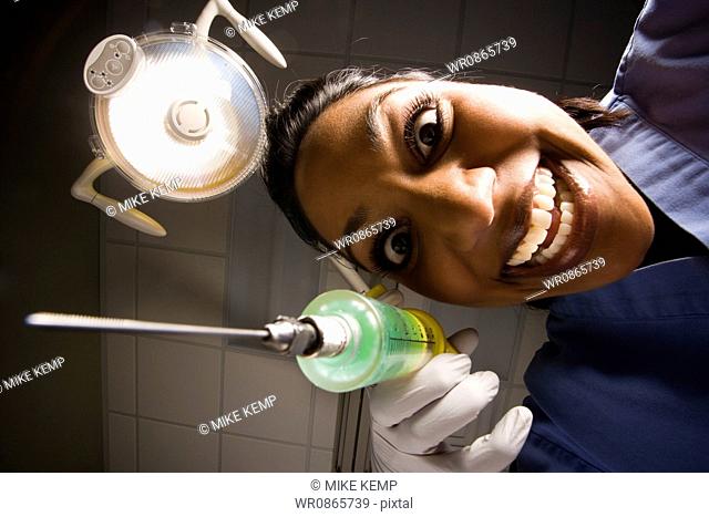 Dental hygienist with syringe dramatic angle