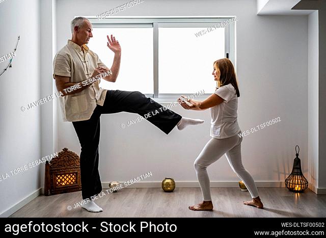 Man and woman practicing martial arts in gym