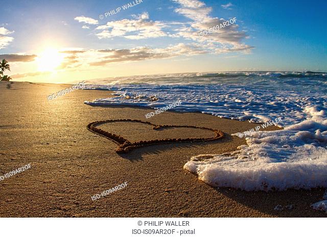 Heart, drawn in sand, sunset