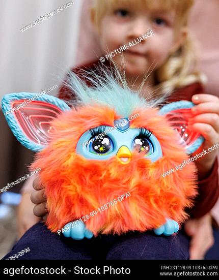 28 November 2023, Bavaria, Nuremberg: Five-year-old Franziska plays with the electronic furry animal Furby from Hasbro at the annual press conference of the...