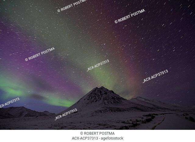 Aurora borealis or northern lights with startrails over Angelcomb Peak, Dempster Highway, Yukon Territory, Canada