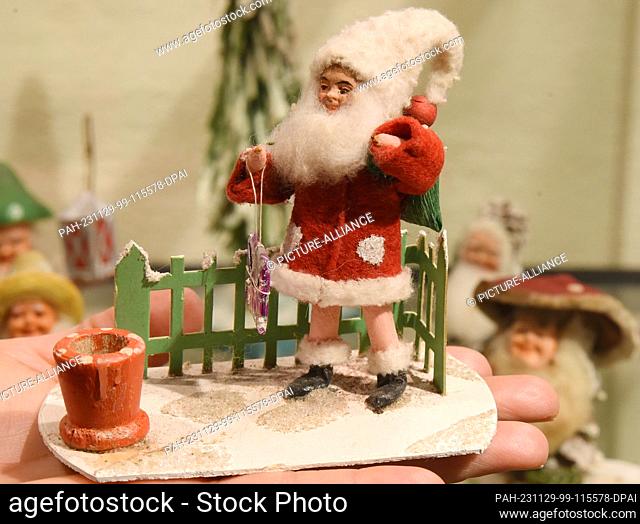 PRODUCTION - 21 November 2023, Saxony, Oschatz: In a special exhibition at the City and Scales Museum, director Dana Bach is holding a Santa Claus on ice skates...