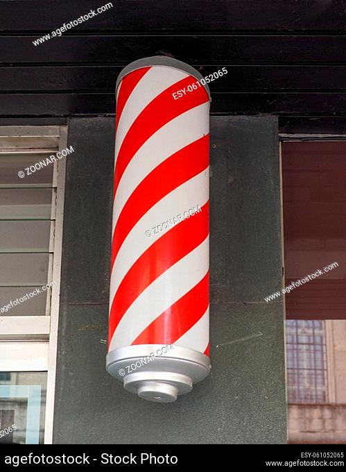 Red and white striped barber sign on a store front