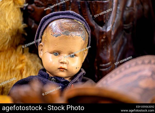 Antique vIntage doll of a little boy with scratched ceramic face, blue cap and blue clothing