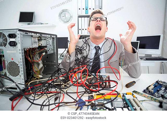 Frustrated man with tangled wires Stock Photos and Images | agefotostock