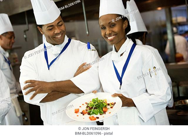 African female chef holding plate of food