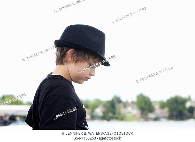 Profile of a ten-year-old boy wearing a hat outdoors