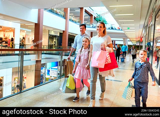 Glückliche Familie mit vielen Einkaufstüten beim Shopping im Einkaufszentrum