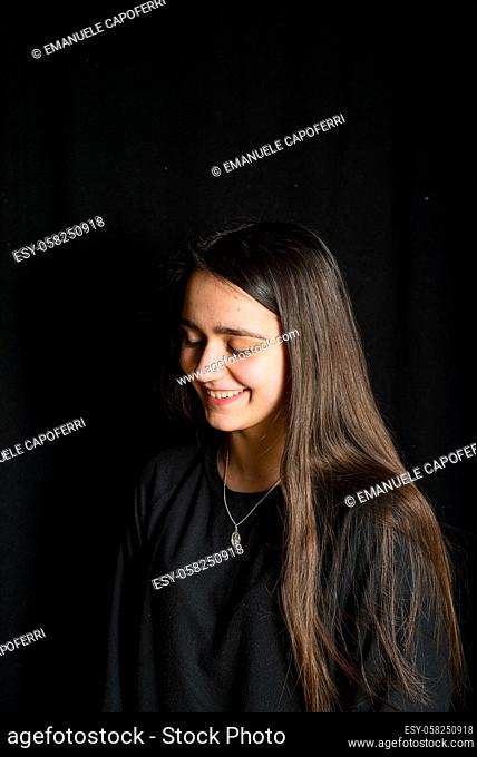 portrait of teenage girl with black background -smiling girl with long hair portrait-