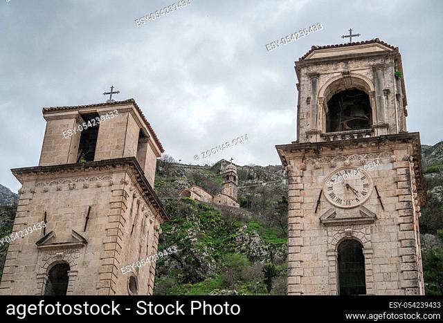 Impressive bell towers of the Cathedral of St Tryphon in the Old Town in Kotor with the Chapel of Our Lady of Salvation on the hillside behind, Montenegro