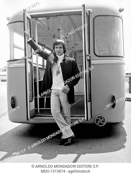 Roberto Carlos leaning up against a bus door. The Brasilian singer Roberto Carlos is leaning up against an open bus door in Milan. Milan, July, 1968
