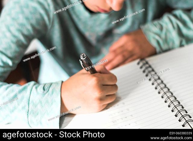 crop kid writing notebook